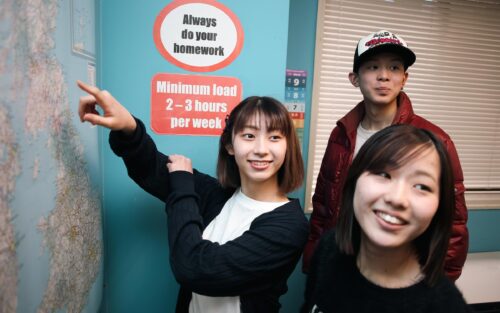UKPLUS Osakaの教室で生徒たちが地図を見ながら英語を学んでいる様子